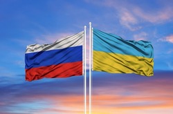 Ukraine and Russia two flags on flagpoles and blue sky