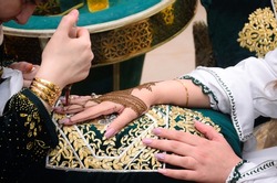 Artist applying henna tattoo on women hands. Mehndi is traditional moroccan decorative art. Close-up, top view