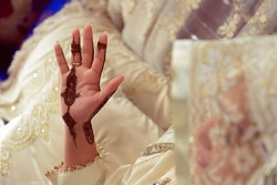 Artist applying henna tattoo on women hands. Mehndi is traditional moroccan decorative art. Close-up, top view
