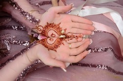 Henna Tattoo on Bride's Hand.Moroccan wedding preparation henna party. Temperate white mehndi. Modern mehendi art.