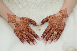 Henna tattoo on the bride's hand. Heart shaped hand. With a wedding ring in the middle
