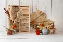 Rustic backdrop made with dried leaves and red little flowers.