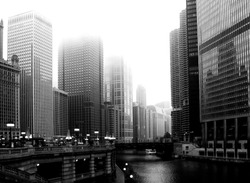 Downtown Chicago under fog with Michigan river, skyscraper office towers and bridge. white tour boat on the canal, street lights in the afternoon fog and reflecting glass curtain walls. office tower 
