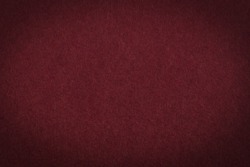 Maroon paper background or texture with vignette