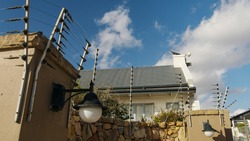 Panning shot of electric fence on a high wall. Property protection, security of residence.