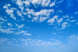 Summer sky. White clouds in the blue sky. Heaven and infinity. Beautiful bright blue background. Light cloudy, good weather. Curly clouds on a sunny day.