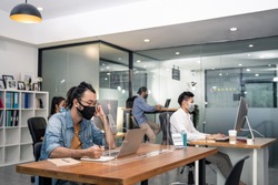 Group of Asian team business people working in office with new normal lifestyle concept. Man and woman wear protective face mask and keep distancing to prevent covid virus after company reopen again.