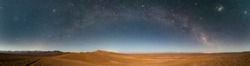 An amazing panoramic view of the Milky Way above Atacama Desert vast sand fields. An awe night sky view with our galaxy arm creating an arch in between the stars. An idyllic and motivational scenery