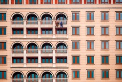 Two climbers on office building/Pair of climbers washing the windows hanging by their ropes on the wall of a tall modern office building