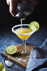 Bartender making margarita cocktail.Close up of classic lime margarita coctail with salt served in martini glass.