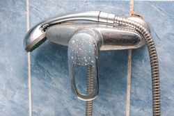 Dirty calcified shower mixer tap, faucet with limescale on it, close up.