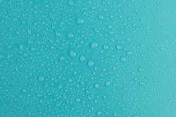 Blue-green background with large and small water drops. The texture of a water drop on a colored background is a top view.