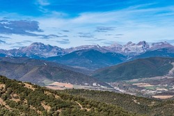 View from viewpoint Santa Cruz de la Seros, Huesca, Spain. The mountains in the background and the blue sky with clouds.