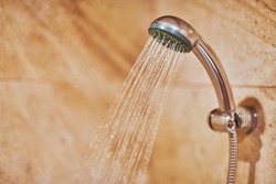 Showerhead in bathroom. Shower head with blurred hot water drops. Take a fresh contrast shower for sweat wash off
