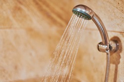 Showerhead in bathroom. Shower head with blurred hot water drops. Take a fresh contrast shower for sweat wash off