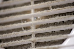 Extremely dirty air ventilation grill of HVAC with dusty clogged filter, close up, macro. Cleaning and disinfecting is required to prevent dust allergies and other lung illnesses and diseases.
