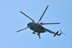 Navy helicopter flying against bright blue sky background, copy space. One military anti-submarine warfare helicopter demonstrating submarine search, bottom view