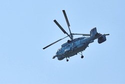 Navy helicopter flying against bright blue sky background, copy space. One military anti-submarine warfare helicopter demonstrating submarine search, side view
