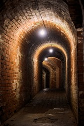 Brick tunnel in old German fort, red brick loft corridor with old wiring, industrial basement of secret military base. Secret passageway of old mansion. Fort No. 5 King Frederick William III