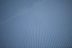 lines in groomed snow on cross country nordic or alpine ski terrain on cold wintery day at ski resort on winter morning in seasonal temperatures