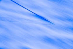 abstract blurry blue and white background of line or rope in snow special effect motion created by long time exposure and intentional camera movement diagonally horizontal backdrop room for type logo