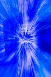 abstract design of blue star burst shaped light special effect created created by zooming in and out lens during long time exposure on birch tree in the woods forest or park outdoors vertical format 