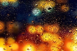 Water drops and condensation in a window glass. Abstract background niglt light.