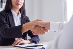 Business women and job seekers shake hands after agreeing to accept a job and approve it as an employee in the company. Or a joint venture agreement between the two businessmen