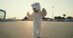 Big funny and cute growth doll of white polar bear running, dancing and having fun outdoor.