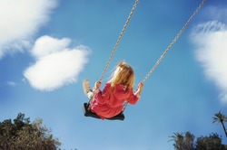 Little girl having fun on a swing outdoor