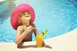Little girl with fresh  cocktail on watter pool in the summer day