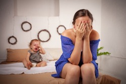 Mom is tired of the baby, wants to rest and sleep. The child screams, hysterical. The woman is tired of the child's cry, she does not want to hear. A one-year-old girl yells from a toothache.