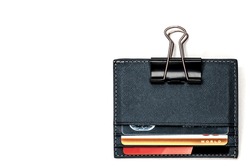 Leather cardholder with credit cards on a white background. Cardholder clamped by a paper clip. The symbol of the electronic wallet