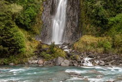 Thunder Creek Falls in Mt Aspiring National Park, with the Haast River in the foreground. Mt Aspiring National Park, West Coast, New Zealand.