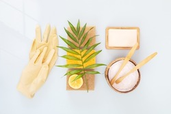 Eco friendly composition with natural cleaning products: organic soap, soda, coconut fiber sponges with lemon, wooden brushes and latex gloves. Various items and ingredients for eco home cleaning