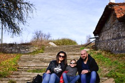 Happy family sitting on stone upstairs. Mother ,father and son at Historic town in the Koprivshtitsa Municipality in Sofia Province, central Bulgaria.Koprivshtitsa is one of the most characteristic Bu