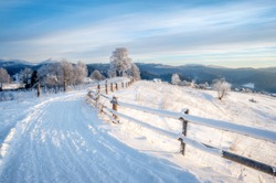 winter landscape. rural road covered with snow. mountains on horizon