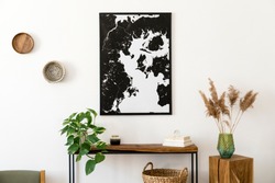 Stylish and cozy scandinavian interior of living room with wooden console, rings on the wall, cube, plants and elegant personal accessories. Black mock up poster map. Design home decor. Template. 
