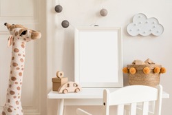 Modern and design scandinavian interior of kidroom with white desk, armachirs, mock up poster frame, natural basket, teddy bear, plush toys and cute children's accessories. 
