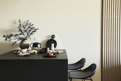 Stylish composition of modern small dining space interior. Black kitchen island and dining accessories. Neutral walls. Minimalistic masculine concept. Details. Template.