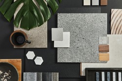 Flat lay of creative architect moodboard composition with samples of building, textile and natural materials and personal accessories. Top view, black backgroung, template.