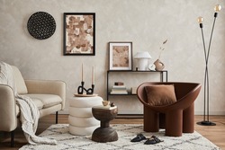 Elegant interior of living room with beige sofa, black console, brown creative armchair, modern lamp, mock up poster frame and stylish home decorations. Copy space. Template.