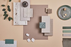 Creative flat lay composition of interior designer moodboard with textile and paint samples, panels and cement tiles. Beige, grey and green color palette. Copy space. Template. 