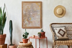 Creative composition of stylish living room interior with mock up poster frame, rattan armchair, coffee table, cacti and personal accessories. Plant love and nature concept. Template.