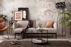 The stylish compostion at living room interior with design gray sofa, wooden coffee table, brown armchair and elegant personal accessories. Loft and industrial interior. Home decor. Template. 