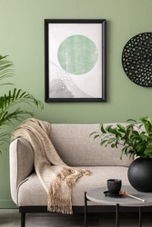 The stylish composition at living room interior with mock up, green wall, design gray sofa, coffee table and elegant personal accessories. Beige pillow and plaid. Mock up poster. Template. 