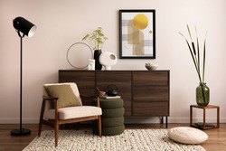 Interior design of harmonized living room with brown commode, design boucle armchair, pouf, lamp, decoration, mock up poster frame and elegant personal accessories. Modern home decor. Template.