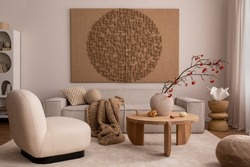 Creative composition of living room interior with mock up poster frame, beige sofa, wooden coffee table, rounded shapes armchair, vase with rowanberry and personal accessories. Home decor. Template.