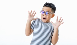Funny cutout portrait of smart young healthy Asian boy wearing glasses and horizontal striped shirt surprisingly raising hands up as shocked, frightened, panic, and scared by unwanted terrified thing