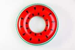 Top view closeup isolated studio shot of colorful red and green watermelon with black seeds round shape swimming pool lifesaver kid rubber ring using on sea beach vacation placed on white background.
